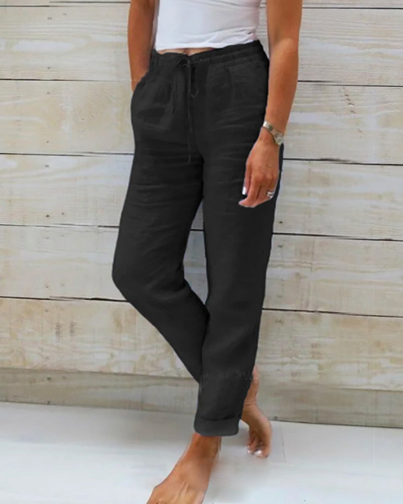 Pantalon noir décontracté pour femme, style ample, poches latérales, porté avec un haut blanc. Mode féminine, tenue confortable, tendance casual.