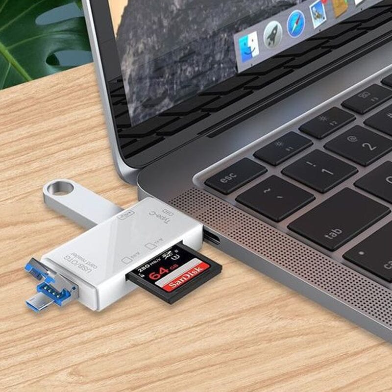 Ordinateur portable avec adaptateur USB-C connecté, lecteur de carte SD inséré, sur bureau en bois. Accessoire technologique pour transfert de données.