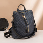 Sac à dos élégant en cuir noir avec motif géométrique, fermetures éclair dorées et bandoulière ajustable. Accessoire mode tendance et pratique.