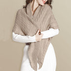 Femme portant un châle en tricot beige, élégant et chaud, sur une robe blanche. Accessoire mode automne-hiver, tendance et confortable.