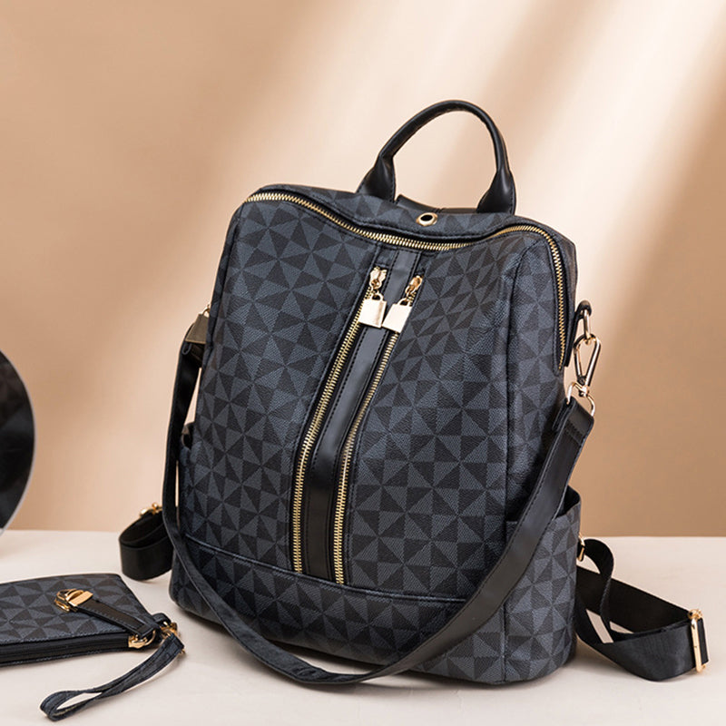 Sac à dos en cuir noir avec motif géométrique, fermetures éclair dorées, bandoulière réglable et poignée supérieure. Accessoire mode élégant.