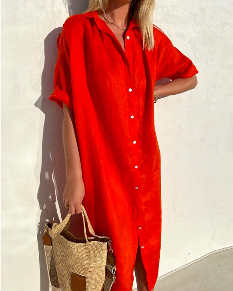 Robe chemise rouge vif en lin portée par une femme, manches courtes, avec sac en paille. Mode estivale, tenue décontractée, style tendance.