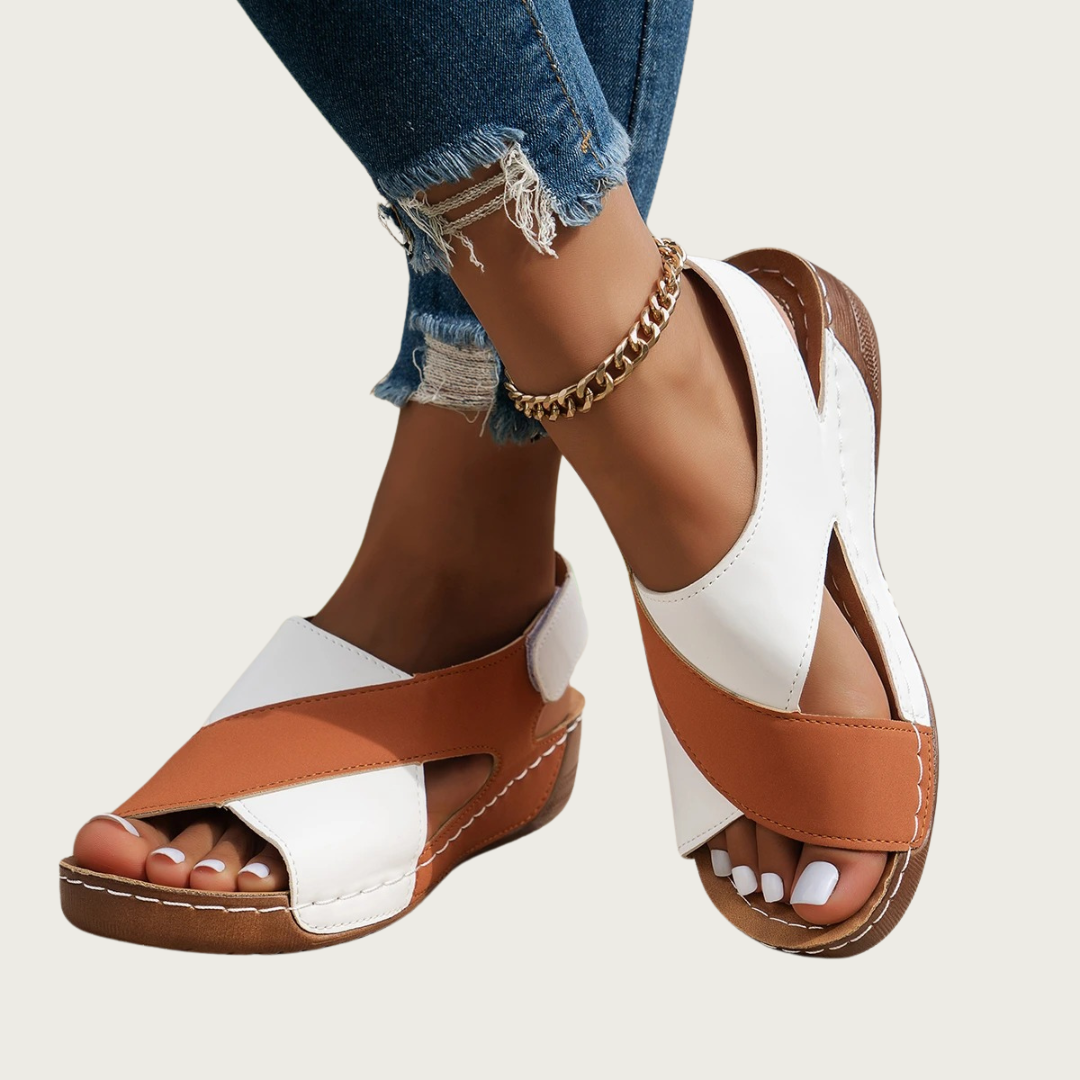 Sandales d'été femme en cuir blanc et marron, avec talon compensé, portées avec un jean déchiré et bracelet chaîne doré. Mode estivale élégante.