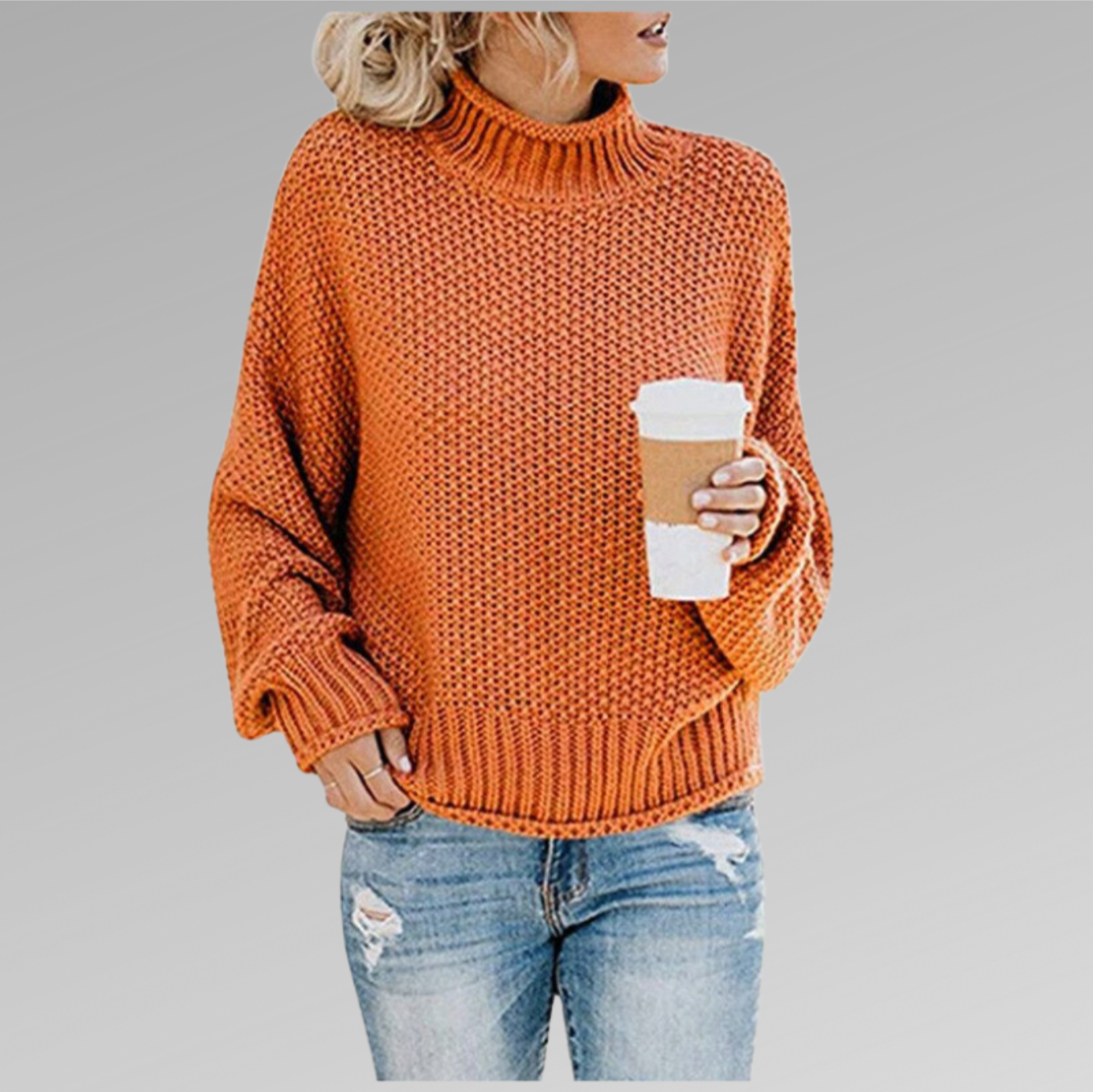 Femme portant un pull orange en maille avec un col roulé, tenant un café à emporter, vêtue d'un jean déchiré. Mode automne, style décontracté.