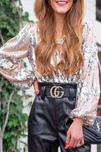 Femme portant un haut à paillettes argentées, pantalon en cuir noir, ceinture Gucci, collier Chanel, sac Yves Saint Laurent, mode élégante.