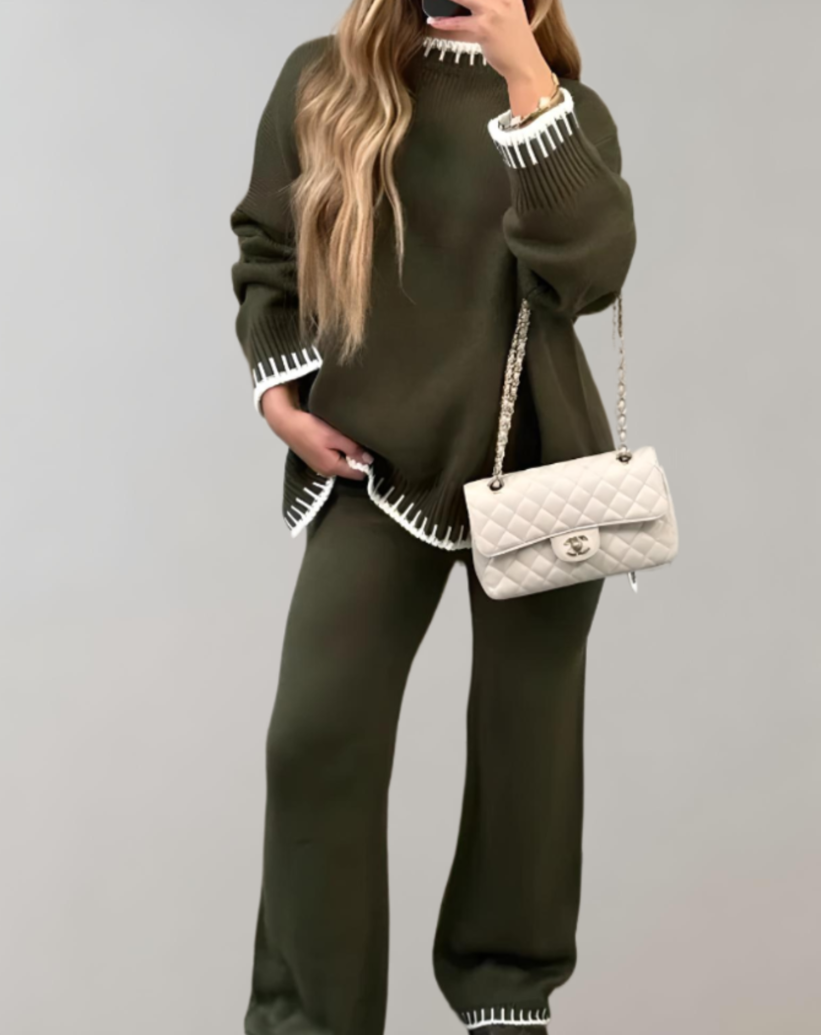Femme en ensemble vert olive avec sac à main blanc Chanel, tenue élégante automne-hiver, mode féminine chic, style décontracté sophistiqué.