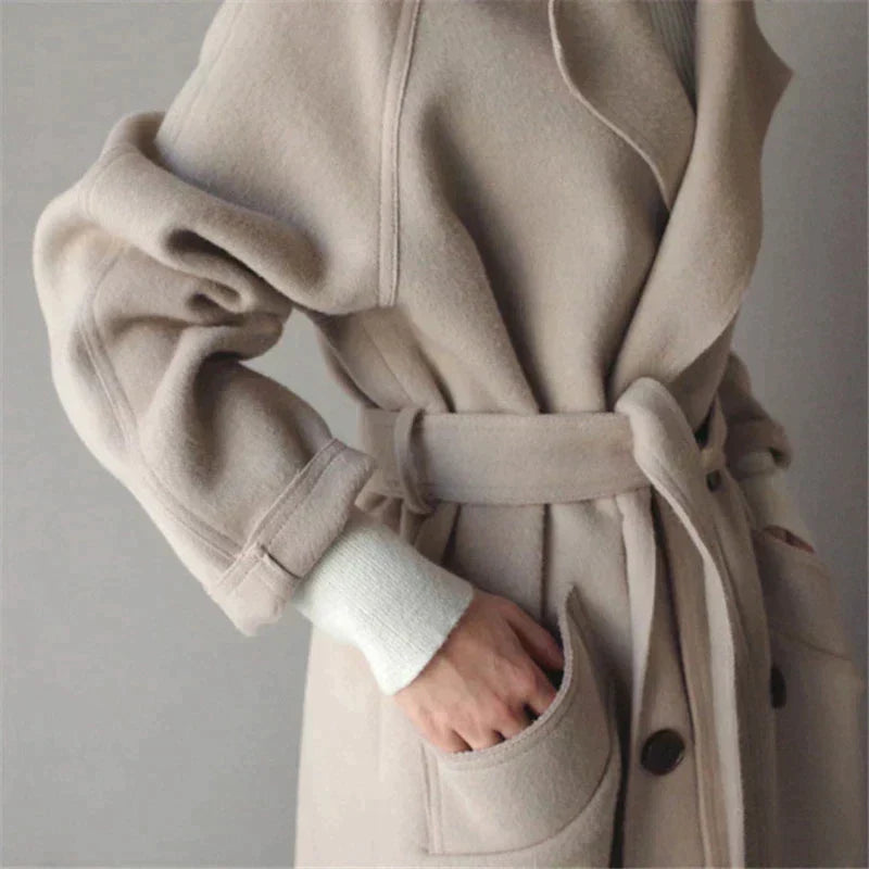 Manteau beige en laine ceinturé, manches longues, poches avant, style élégant et moderne, mode automne-hiver, vêtement chaud pour femme.