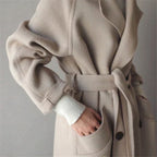 Manteau beige en laine ceinturé, manches longues, poches avant, style élégant et moderne, mode automne-hiver, vêtement chaud pour femme.