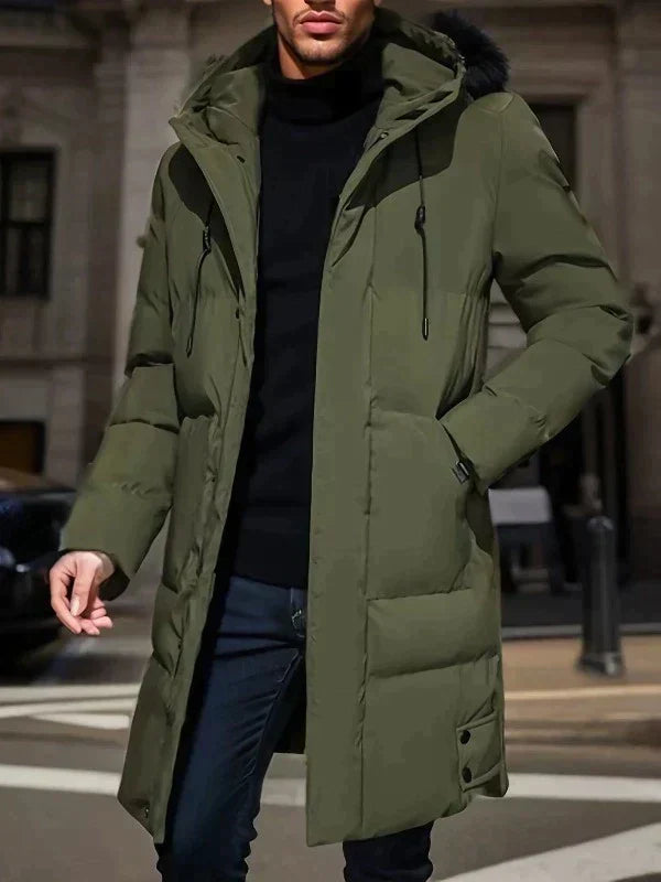 Homme portant un manteau d'hiver vert kaki avec capuche, style urbain. Mode masculine, vêtement chaud, tendance hiver, rue de la ville.