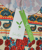 Étiquette de vêtement colorée avec motifs floraux et cachemire, logo vert Barbara Mode. Mode éthique, design vibrant, tendance bohème.