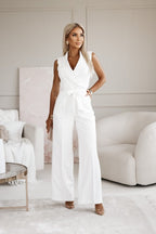 Femme élégante en combinaison blanche, posant dans un salon moderne. Mode féminine, style chic, tenue tendance, décoration intérieure minimaliste.