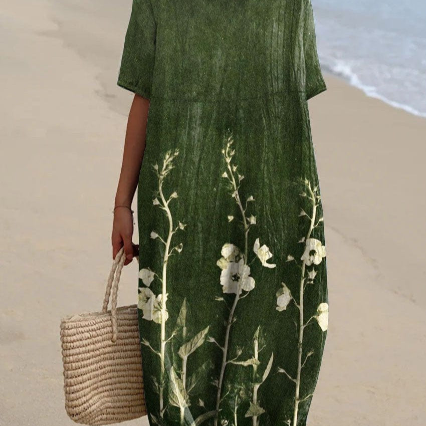 Robe verte à fleurs blanches portée par une femme sur la plage, tenant un sac en osier. Mode estivale, tenue décontractée, style plage.