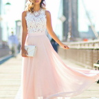 Robe de soirée élégante rose pâle avec haut en dentelle blanche, portée par une femme sur un pont urbain. Mode féminine chic et tendance.