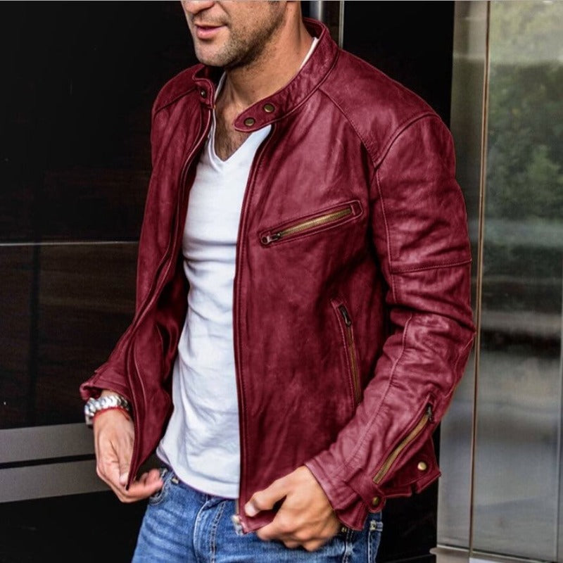 Homme portant un blouson en cuir rouge, style motard, avec fermeture éclair, sur un t-shirt blanc et un jean. Mode masculine élégante et moderne.