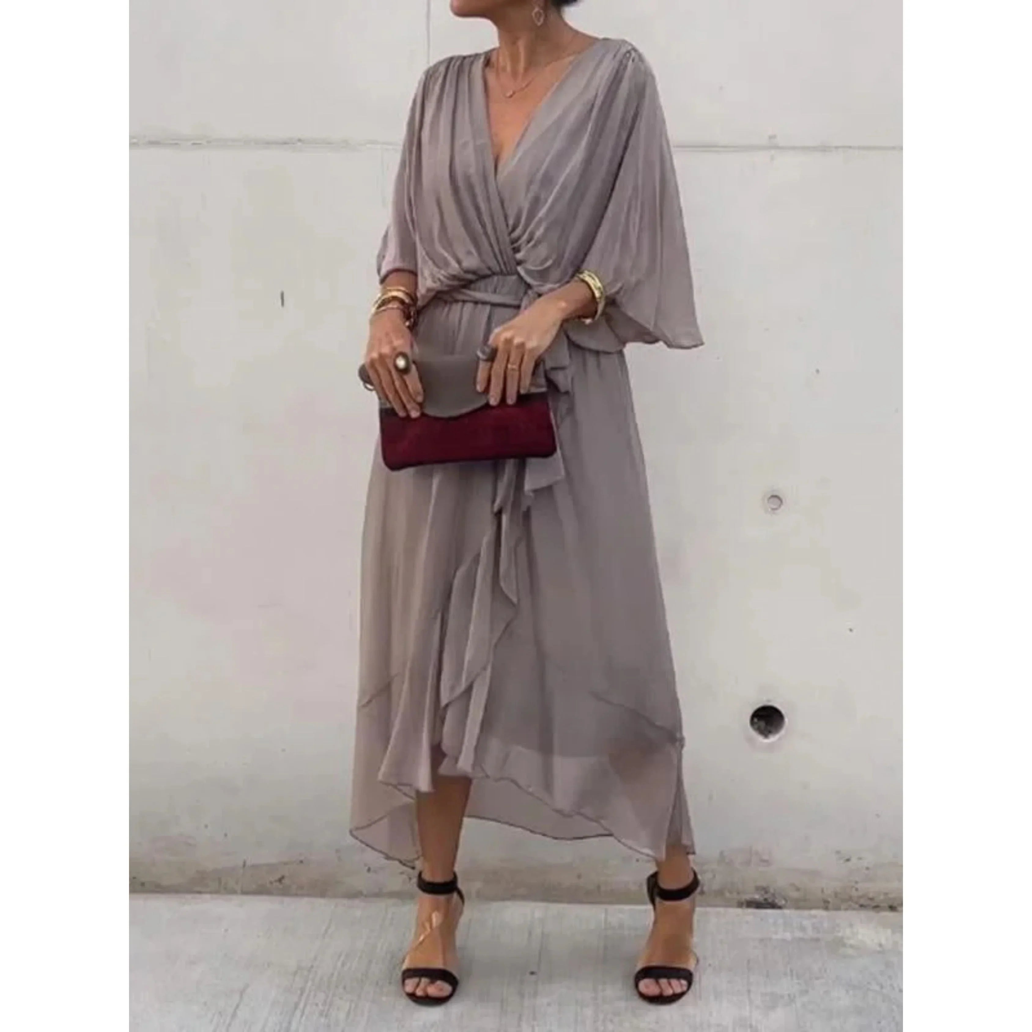 Robe midi grise élégante avec manches chauve-souris, ceinture drapée, pochette bordeaux, sandales à talons noires. Mode féminine chic et tendance.