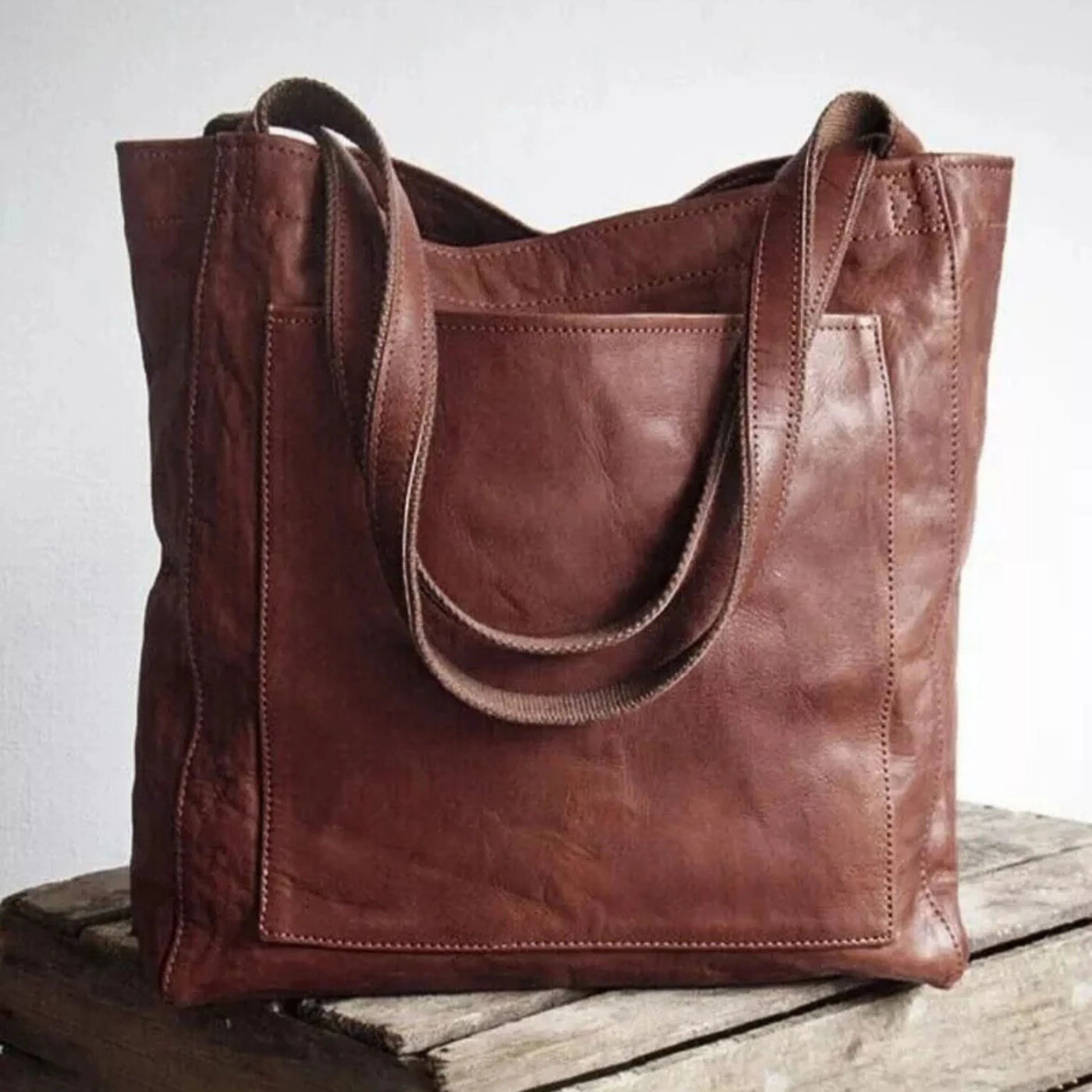 Sac à main en cuir marron sur une table en bois, design élégant et pratique, idéal pour la mode féminine, accessoire tendance et durable.