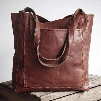 Sac à main en cuir marron sur une table en bois, design élégant et pratique, idéal pour la mode féminine, accessoire tendance et durable.