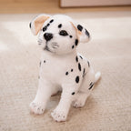 Peluche dalmatien réaliste assise sur un tapis beige, avec des taches noires distinctes et des oreilles tombantes. Jouet doux pour enfants.