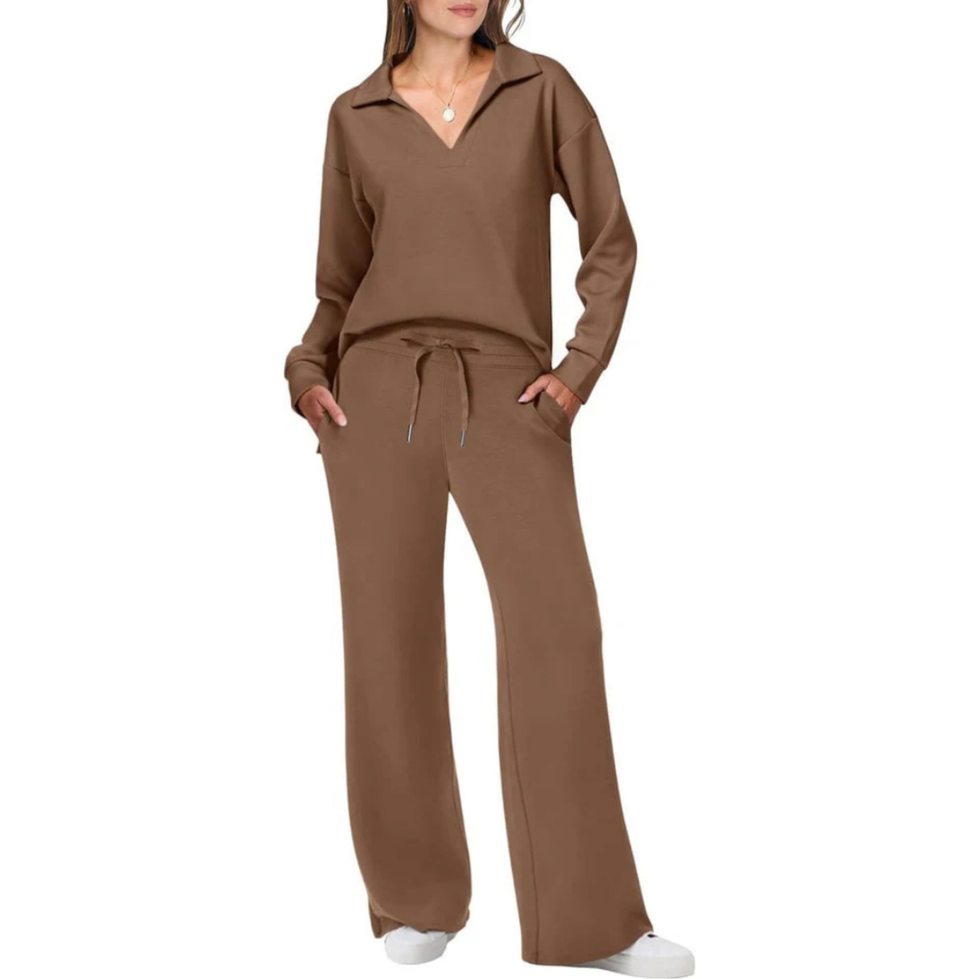 Femme portant un ensemble décontracté marron, composé d'un pull à col en V et d'un pantalon large, avec des baskets blanches. Mode confortable et élégante.