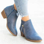 Bottines en cuir bleu pour femme avec fermeture éclair, talon bas, portées avec un jean déchiré. Chaussures tendance automne-hiver.