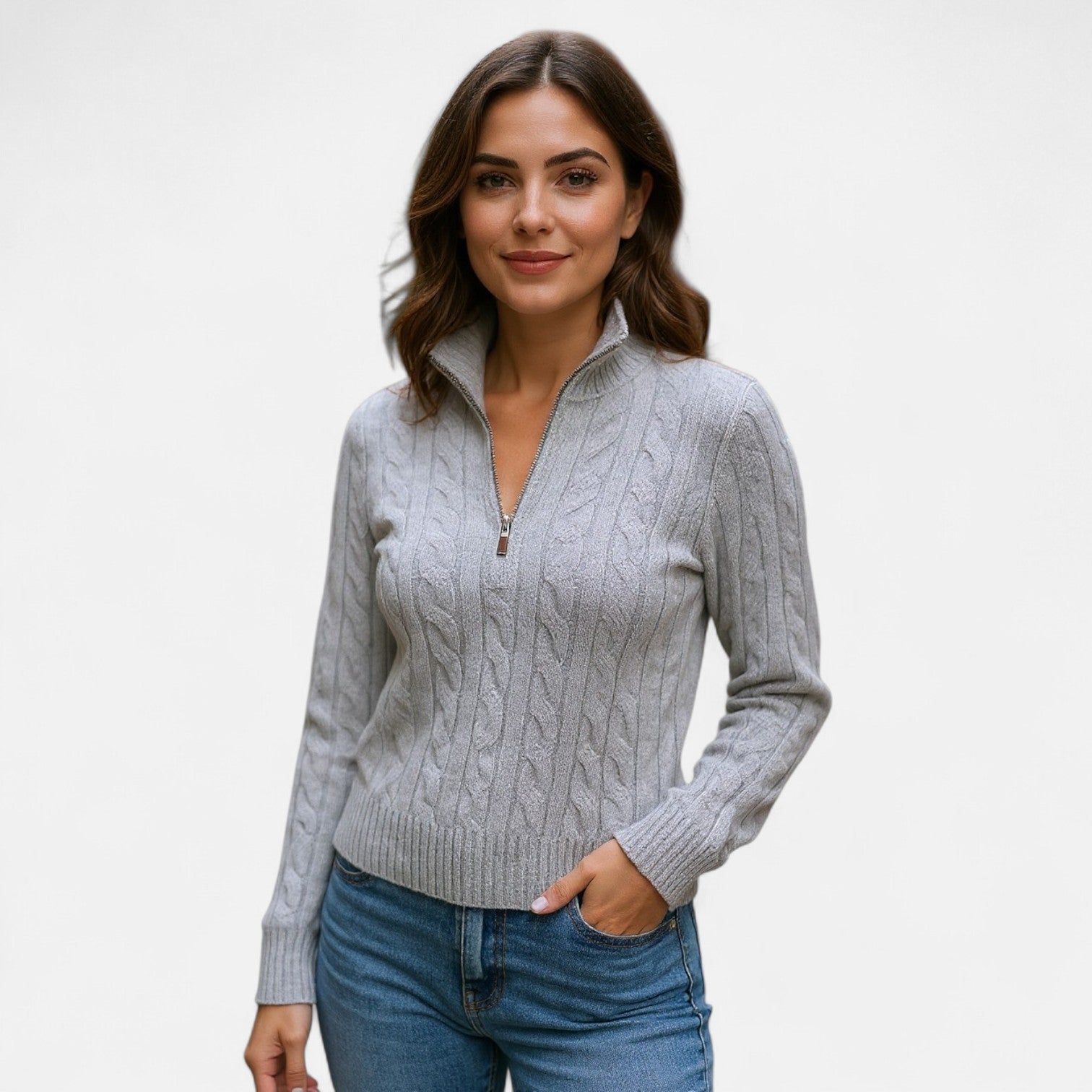 Jeune femme portant un pull gris à col zippé et motif torsadé, posant avec confiance. Mode automne, style décontracté, tendance féminine.