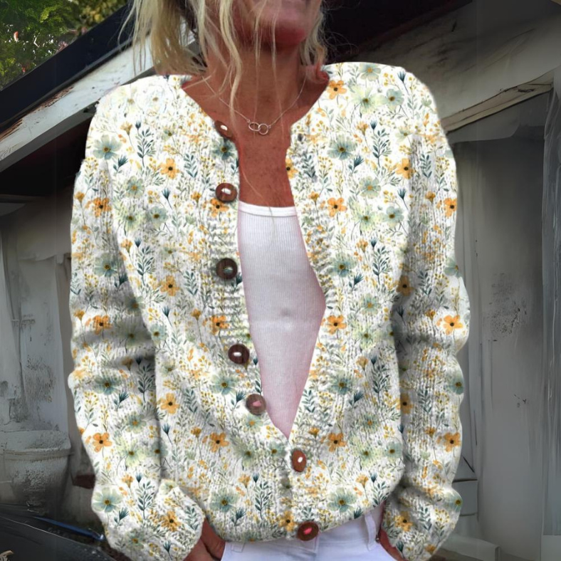 Femme portant un cardigan tricoté à motifs floraux, boutons en bois, sur un débardeur blanc. Mode automne, style décontracté, tendance 2023.
