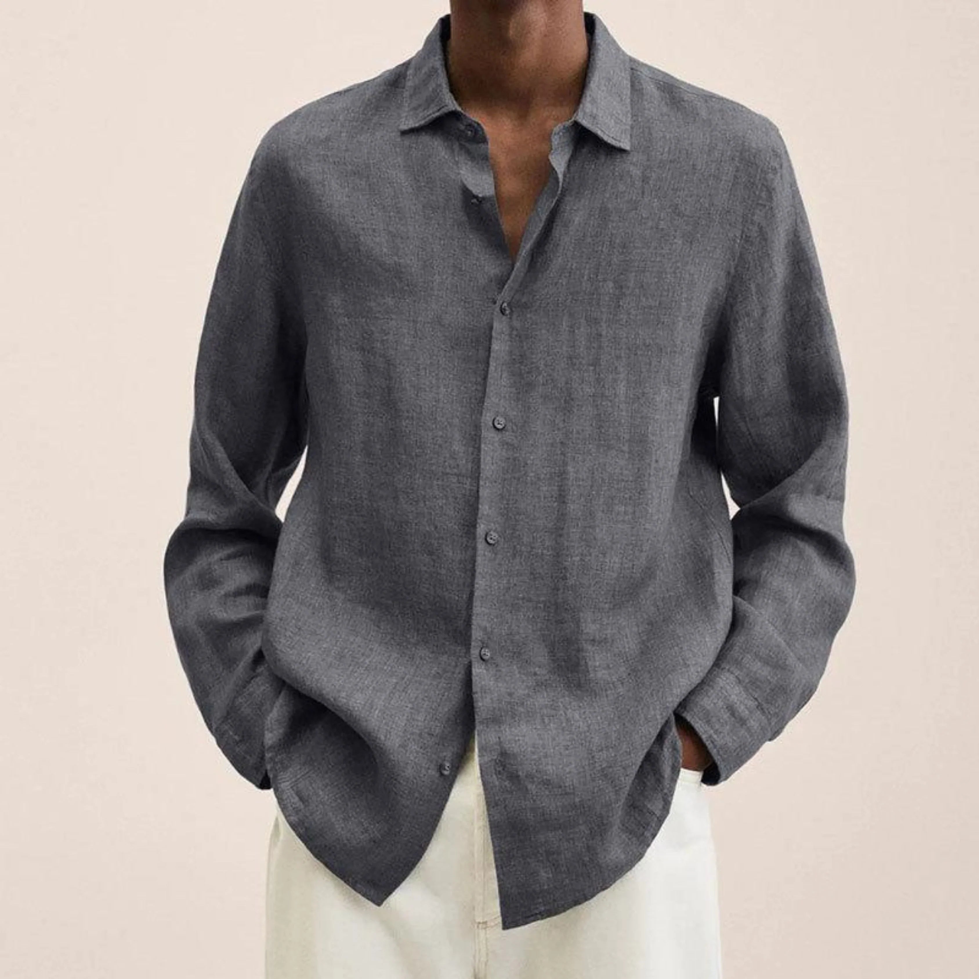 Chemise en lin gris pour homme, manches longues, col classique, portée avec un pantalon blanc. Mode masculine élégante et décontractée.