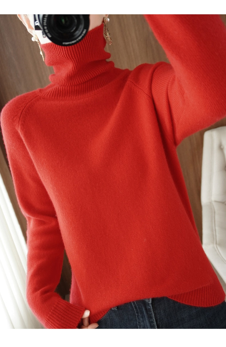 Pull-over rouge à col roulé en laine, porté par une personne, capturé en intérieur. Mode automne-hiver, style élégant et confortable.