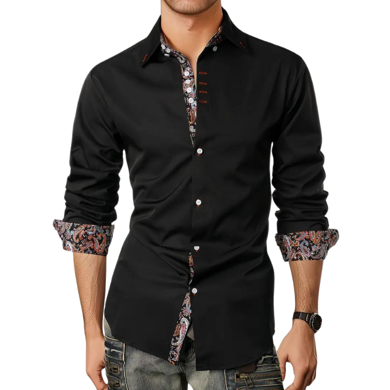 Homme portant une chemise noire élégante avec détails floraux, manches retroussées, boutons blancs, associée à un jean décontracté. Mode masculine chic.