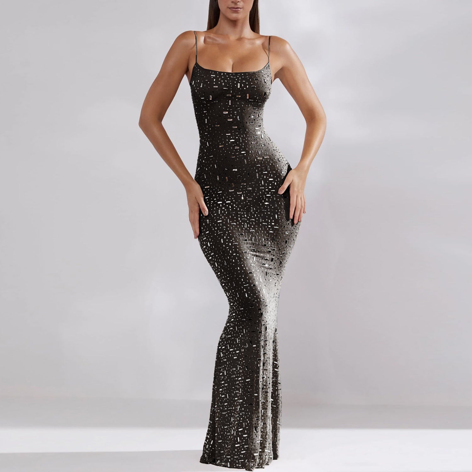 Robe longue moulante à paillettes noires, élégante et scintillante, portée par une femme. Mode soirée glamour, tenue chic et tendance.