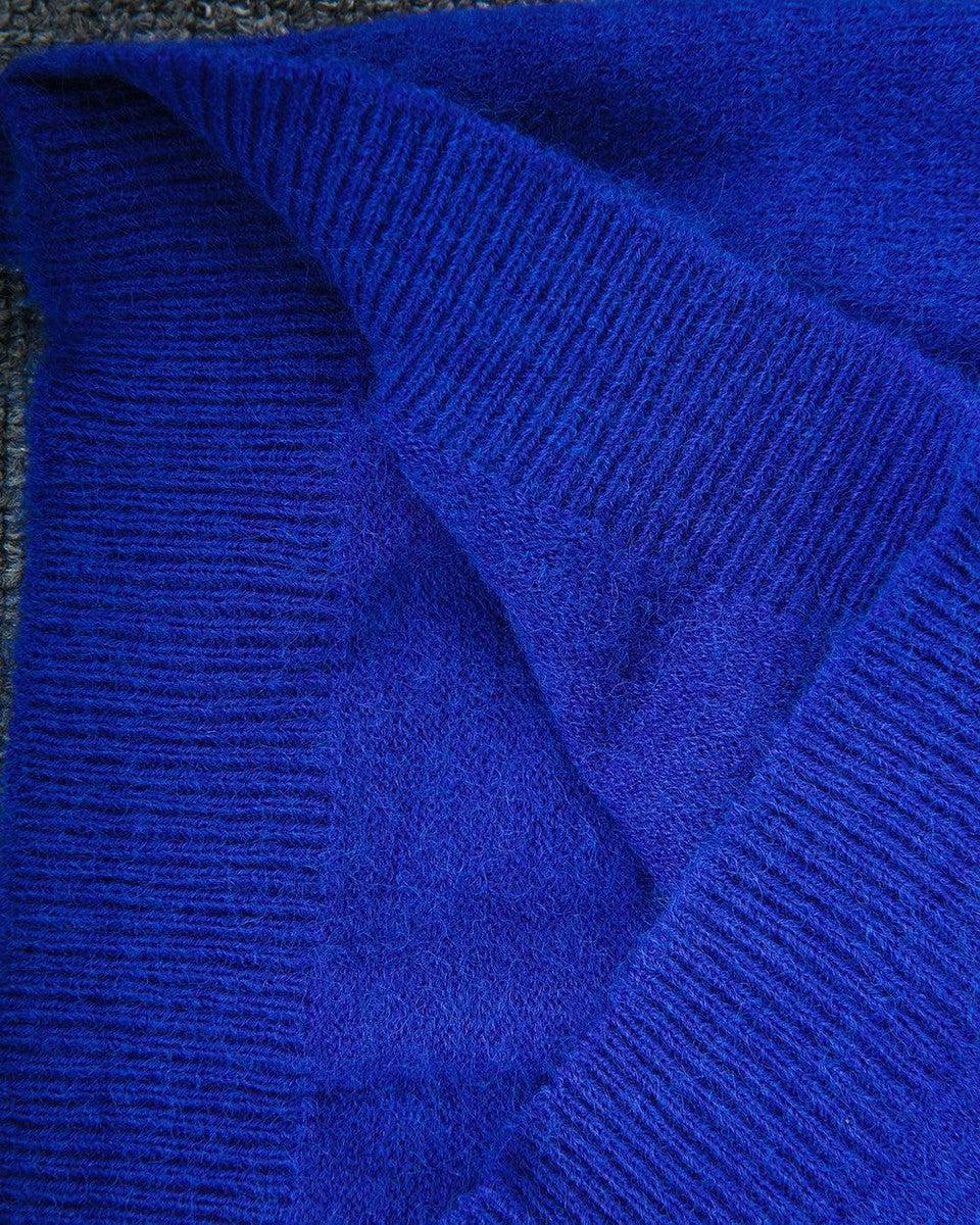 Écharpe en laine bleue, texture douce et épaisse, tricotée à la main, idéale pour l'hiver. Accessoire mode chaud et élégant.