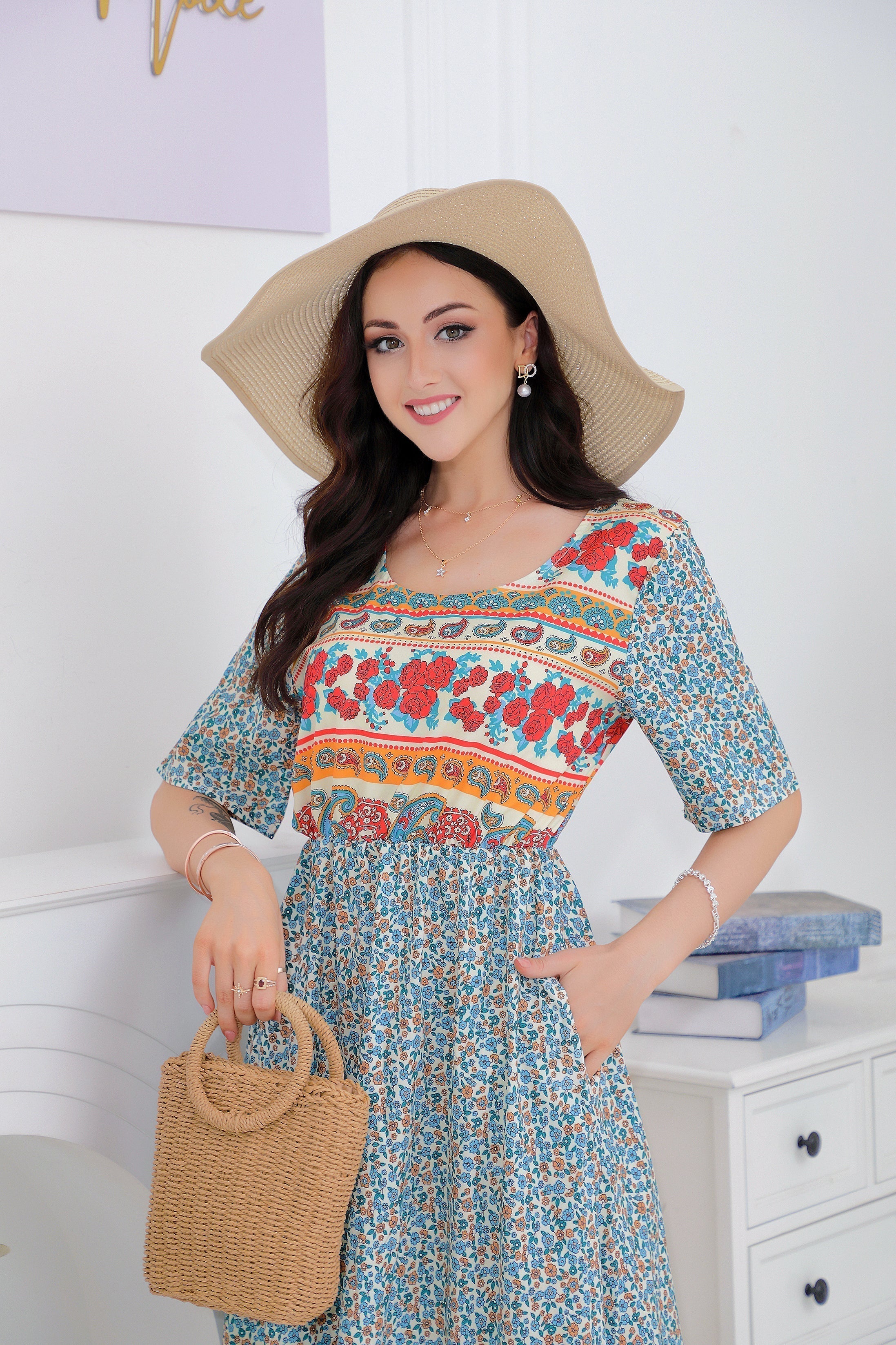 Femme souriante en robe fleurie colorée, chapeau de paille, tenant un sac en osier. Mode estivale élégante, style bohème chic.