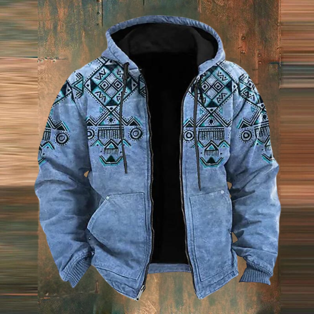 Veste en jean bleue avec motifs géométriques ethniques, capuche et doublure noire, sur fond texturé. Mode homme, style décontracté, tendance.