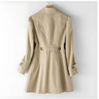Manteau trench beige élégant pour femme, avec ceinture et boutons, suspendu sur un cintre. Mode automne, style classique intemporel.