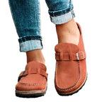 Chaussures mocassins en cuir marron pour femme, avec boucle décorative, portées avec un jean retroussé. Mode féminine, confort, style décontracté.