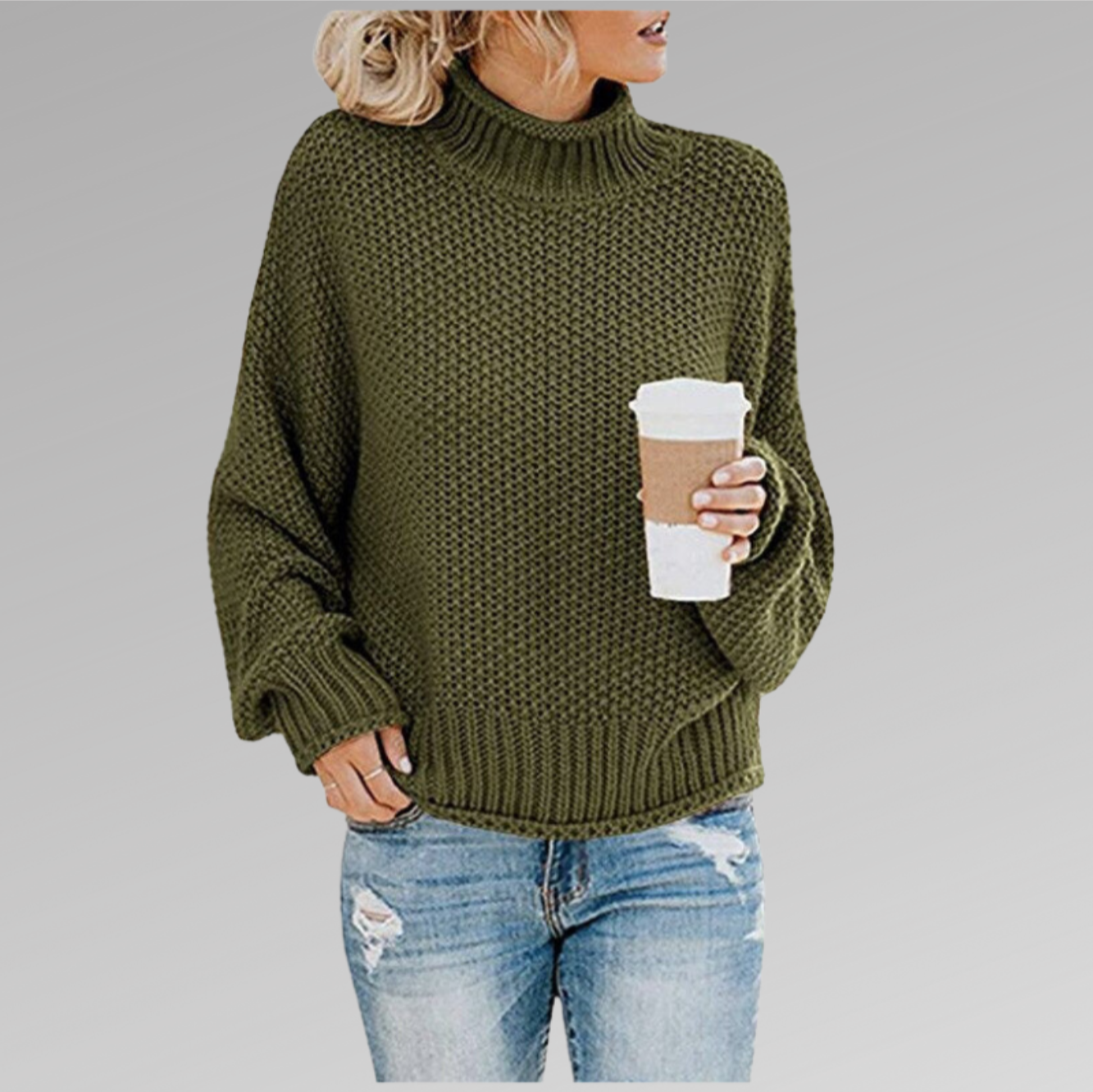 Femme en pull vert en maille, tenant un gobelet de café, portant un jean déchiré. Mode automne, style décontracté, tendance vêtements chauds.