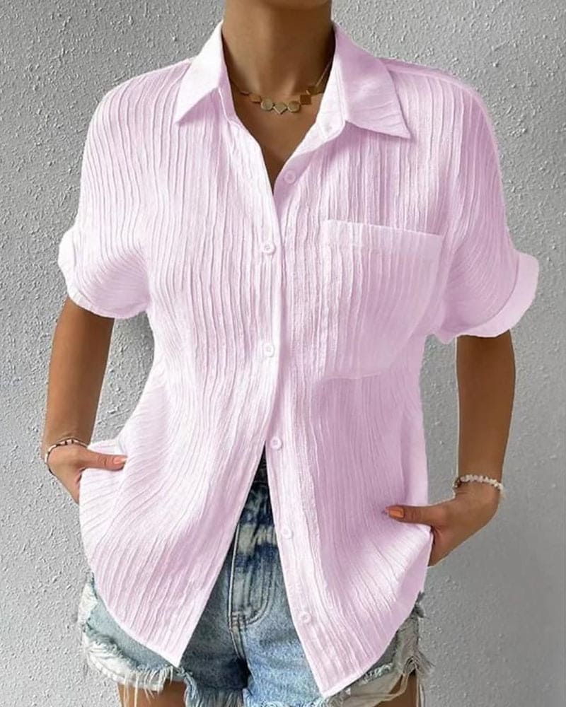 Chemise rose en lin à manches courtes pour femme, style décontracté, avec poche poitrine, portée avec un short en jean. Mode estivale tendance.