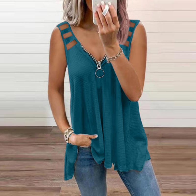 Femme portant un débardeur bleu à fermeture éclair et bretelles doubles, posant devant un mur en bois. Mode décontractée, tendance été.