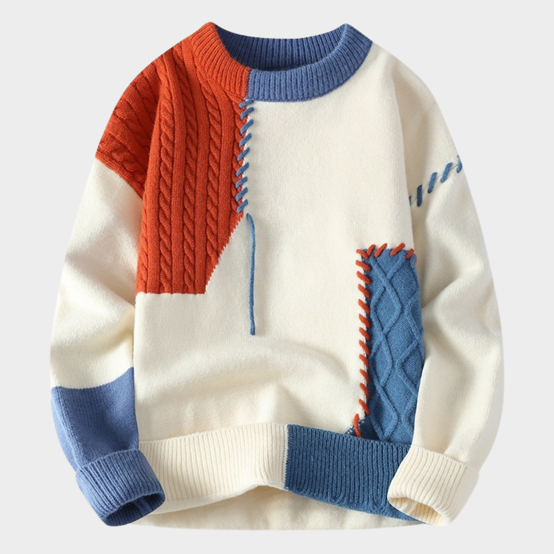 Pull en laine multicolore pour homme, design patchwork avec motifs géométriques, manches longues, col rond, couleurs rouge, bleu et blanc cassé.