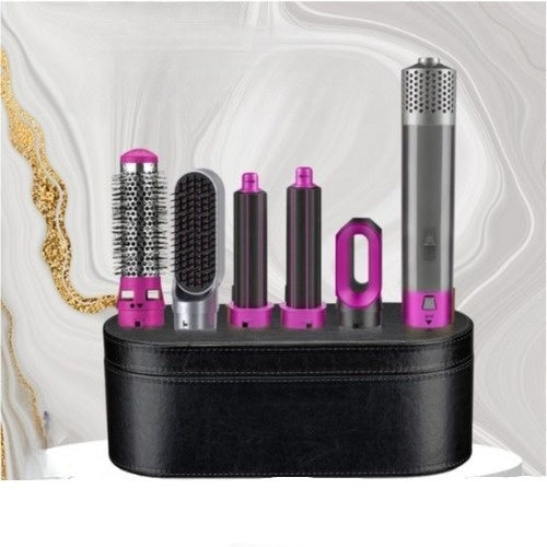 Coffret de coiffure multifonction avec sèche-cheveux, brosses et accessoires violets sur fond marbré. Outils de coiffure professionnels.