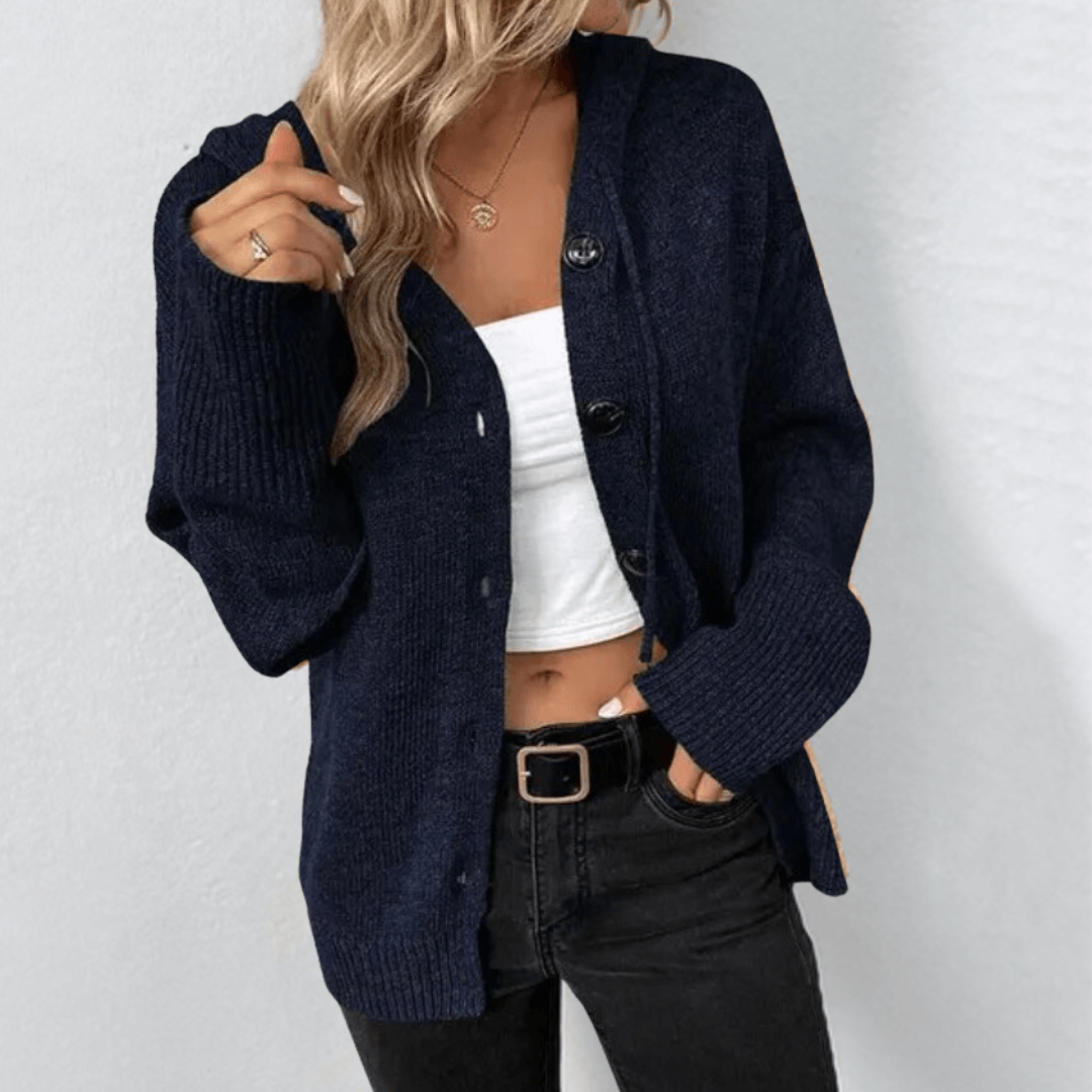 Femme portant un cardigan bleu marine, débardeur blanc et jean noir. Mode automne, style décontracté, tendance vêtements femme.