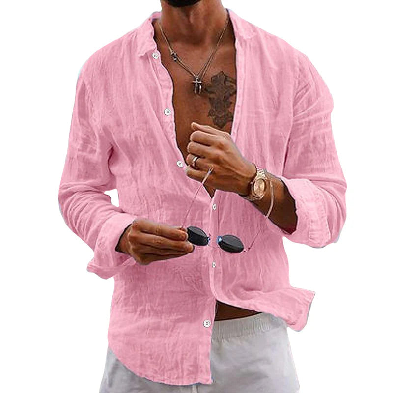 Homme portant une chemise en lin rose, manches retroussées, tenant des lunettes de soleil. Style décontracté, mode estivale masculine.
