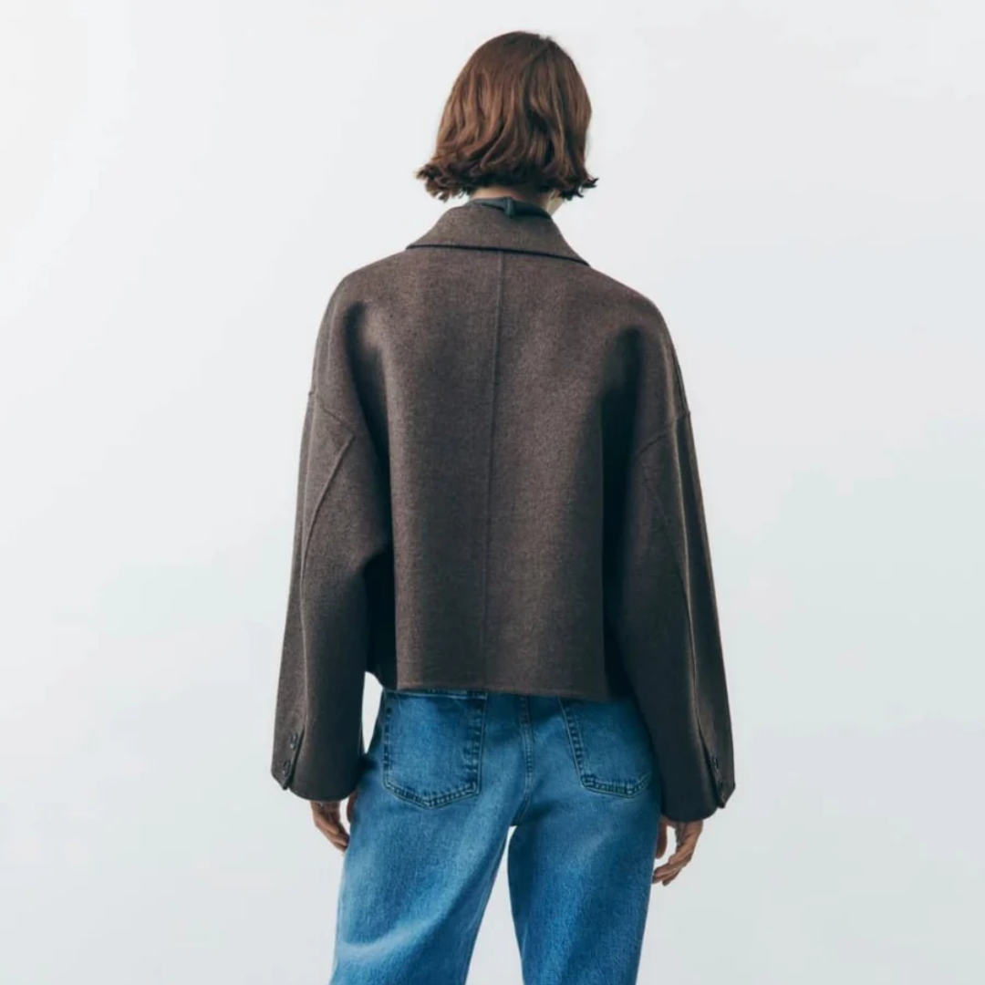 Veste marron oversize en laine, vue de dos, portée par une femme en jean bleu. Mode automne-hiver, style décontracté et tendance.