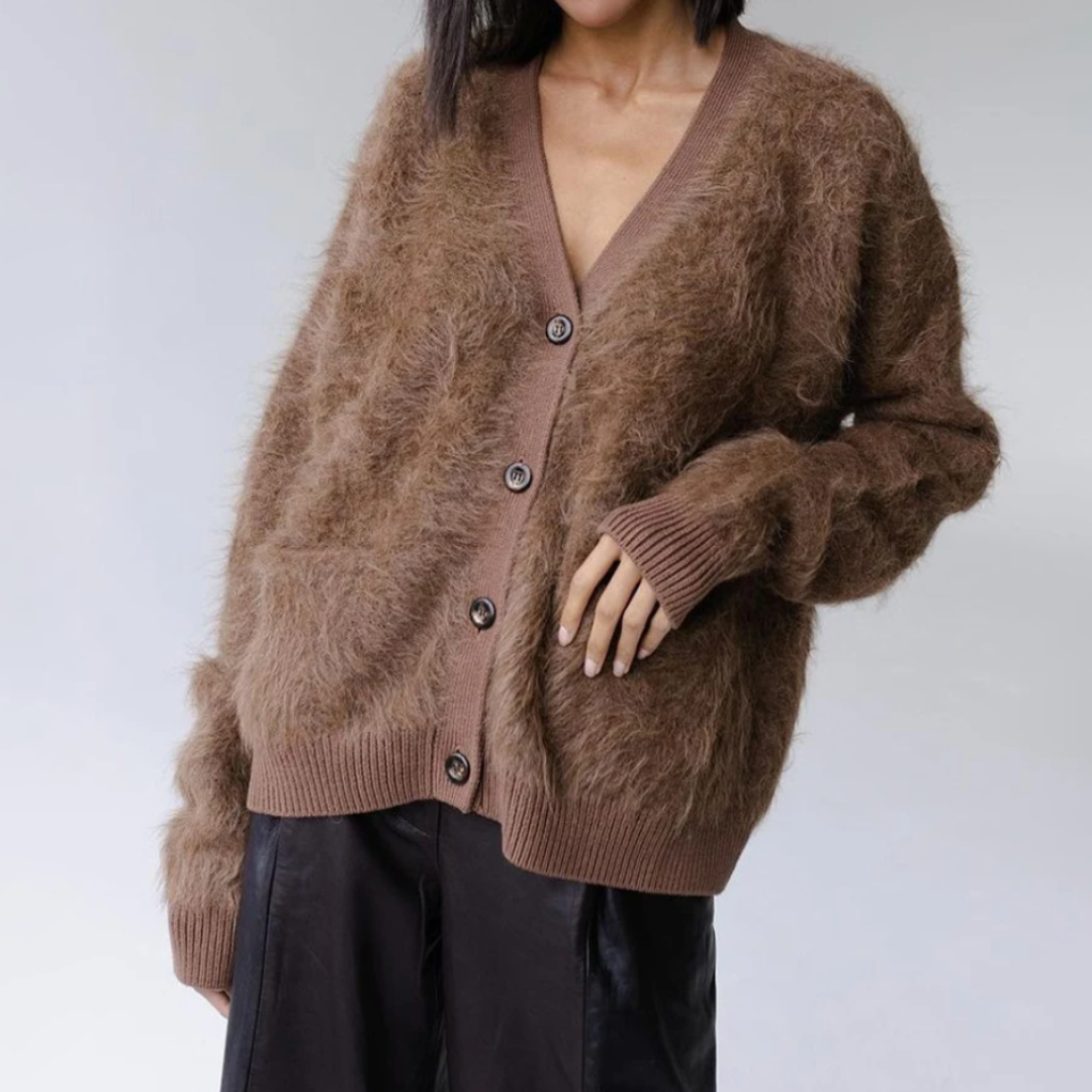 Femme portant un cardigan marron en mohair avec boutons, manches longues, sur fond neutre. Mode automne-hiver, style décontracté et élégant.