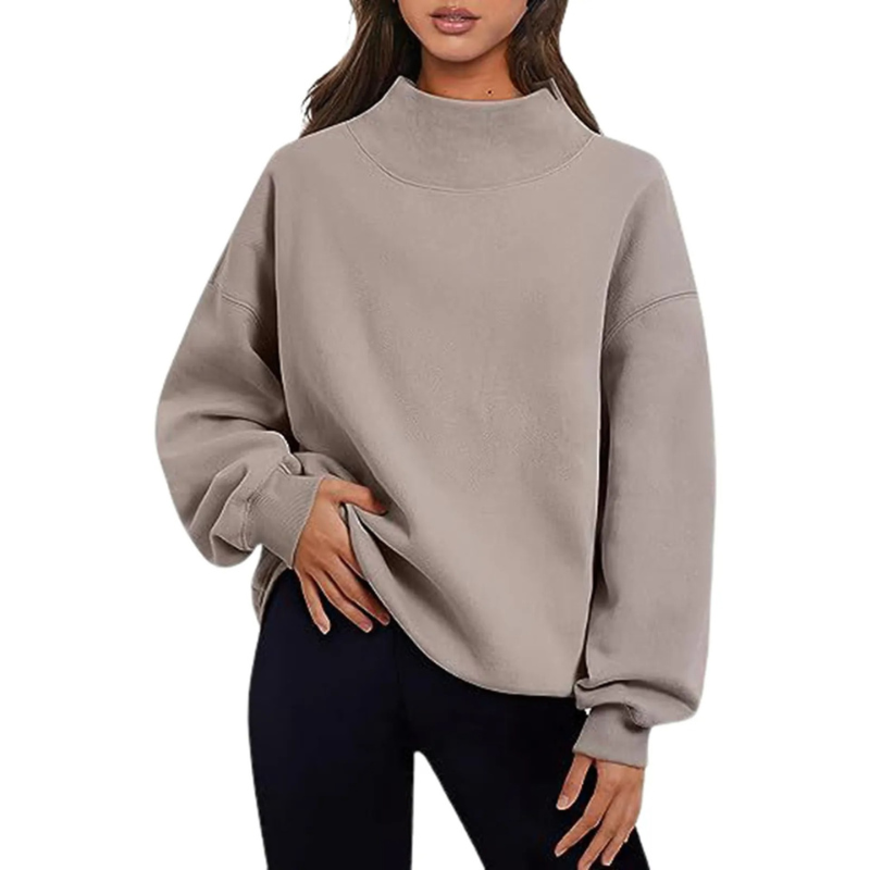 Femme portant un pull beige à col montant, manches longues, style décontracté. Mode automne-hiver, tenue confortable et élégante.