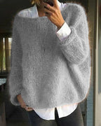 Pull-over gris en laine mohair, ample et texturé, porté sur une chemise blanche. Mode automne-hiver, style décontracté et élégant.