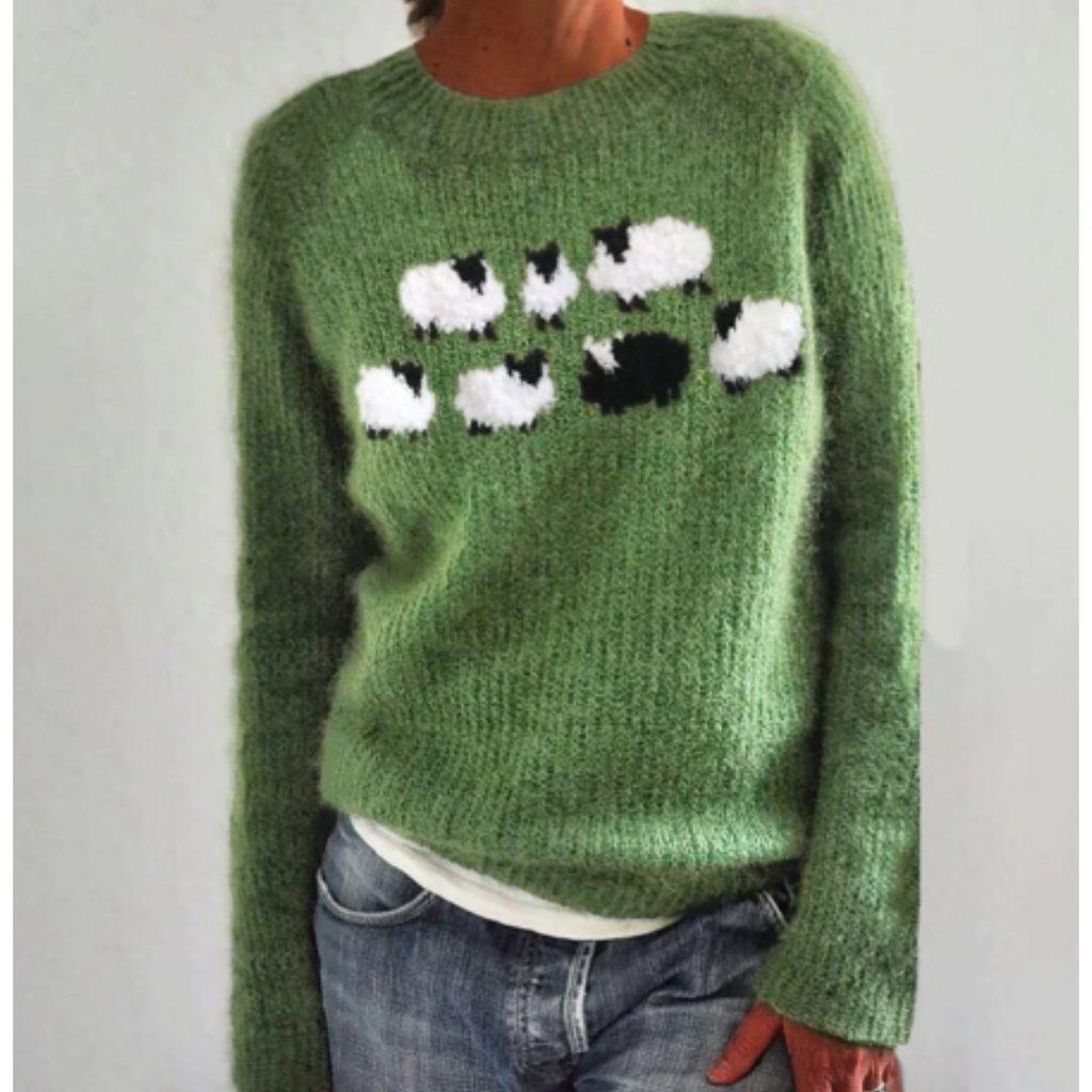 Pull vert en laine avec motif moutons noirs et blancs, manches longues, porté par une personne. Mode automne, style décontracté, tendance tricot.