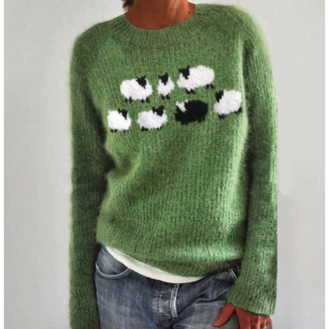 Pull vert en laine avec motif moutons noirs et blancs, manches longues, porté par une personne. Mode automne, style décontracté, tendance tricot.
