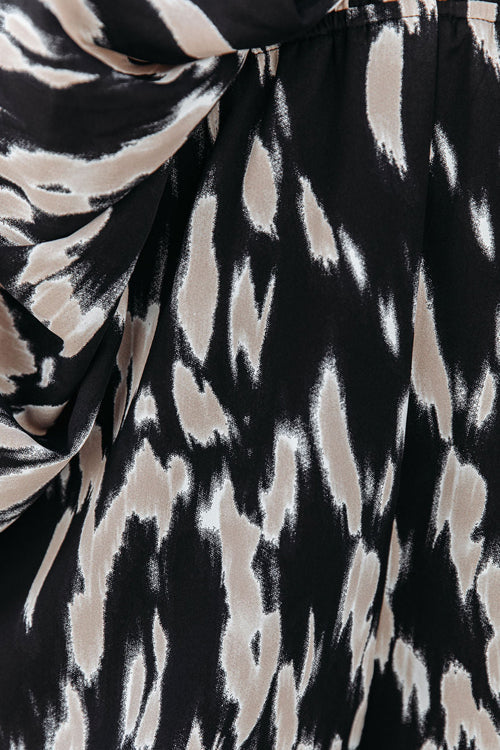 Motif abstrait noir et beige sur tissu, style animalier. Design moderne, texture fluide, idéal pour mode et décoration intérieure.