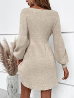 Robe pull beige en tricot avec manches longues bouffantes, femme de dos, style automne-hiver, élégance décontractée, décor pampas.